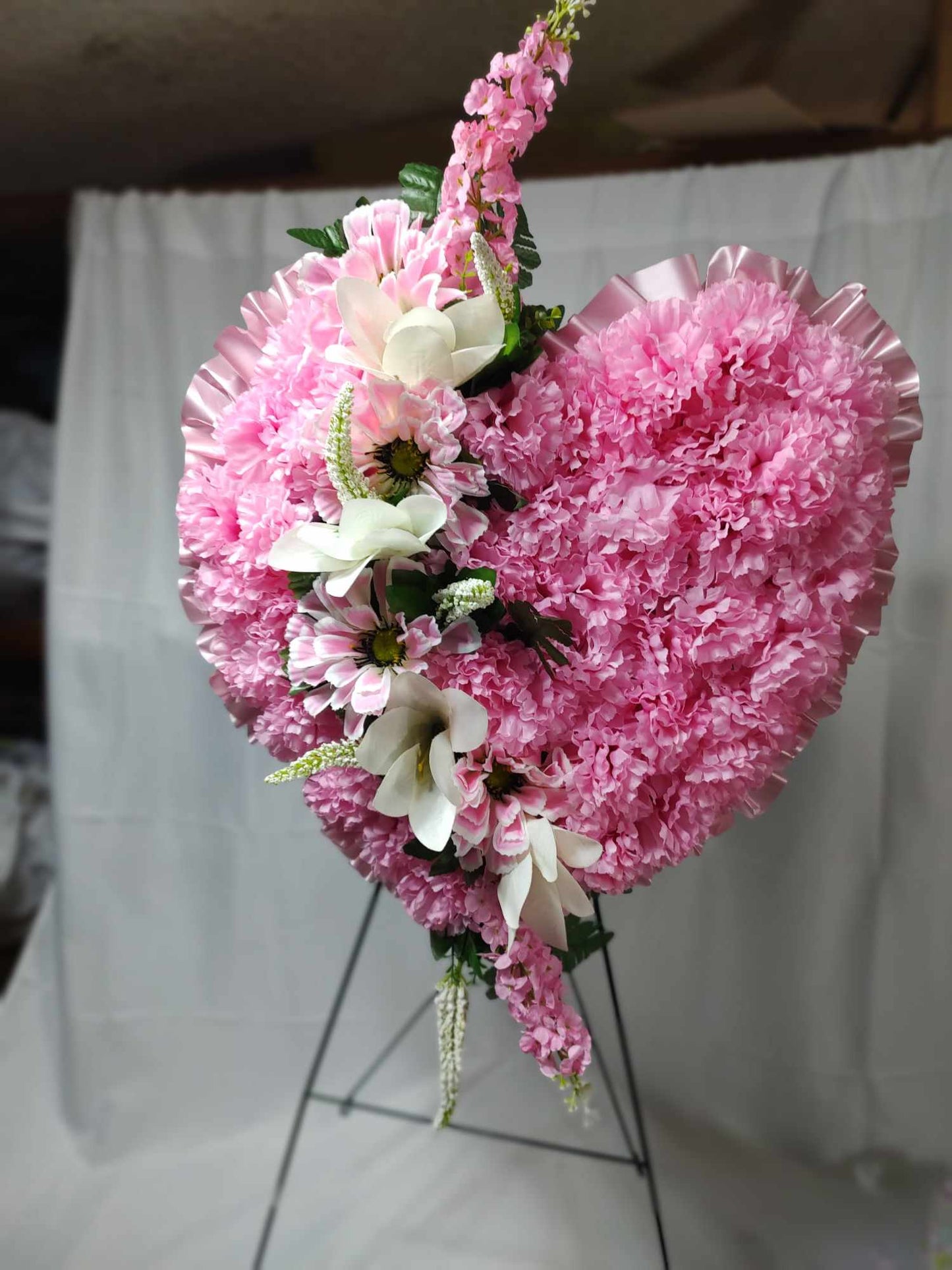 Pink and white heart funeral arrangement in stock